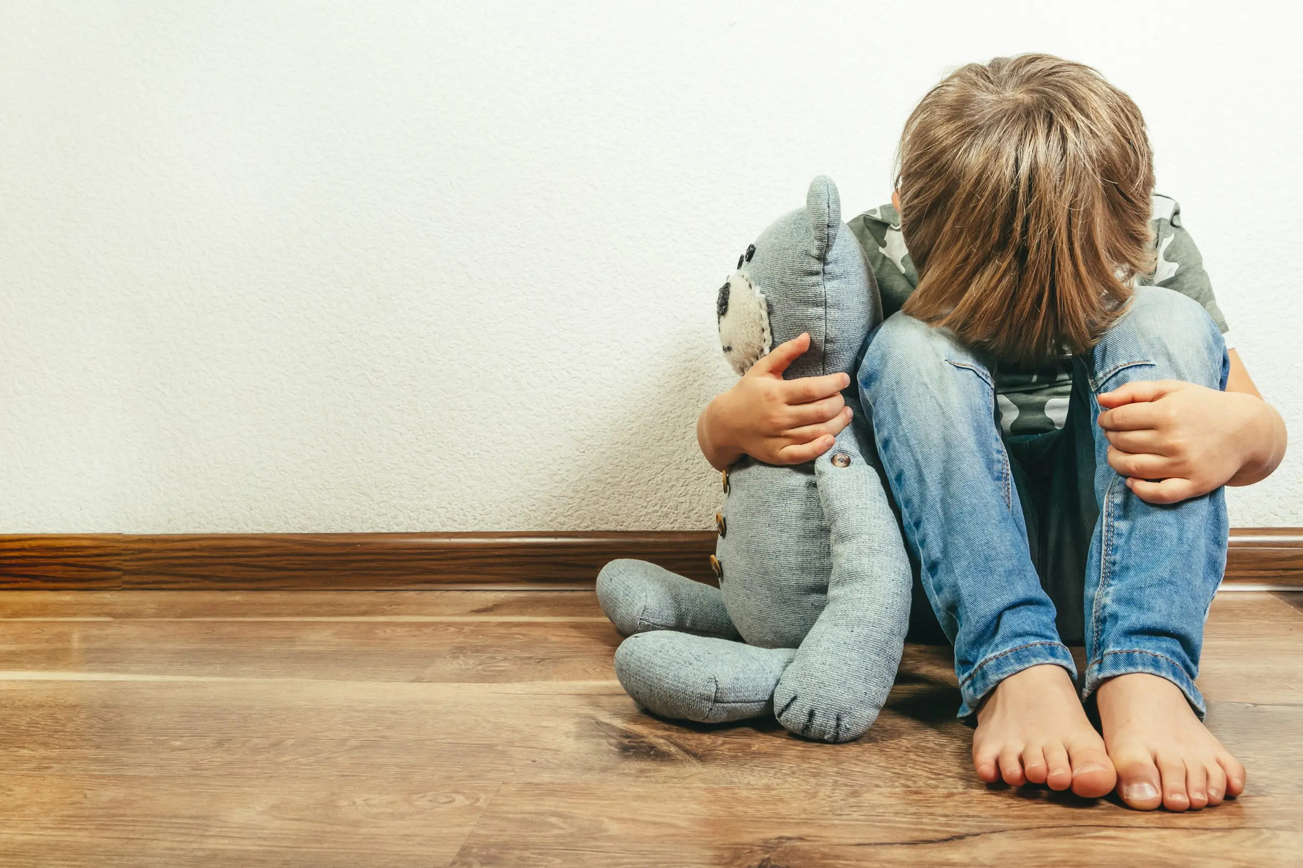 Sad depressed boy with a teddy bear