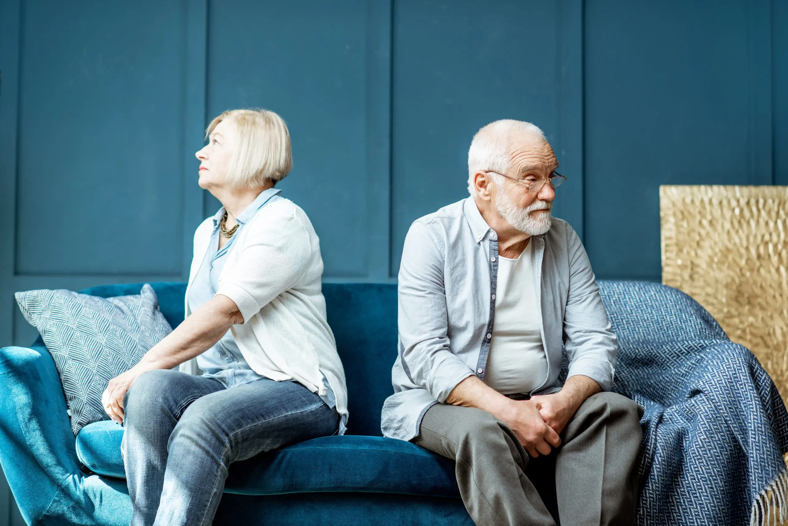 Senior couple sitting on the couch after having an argument